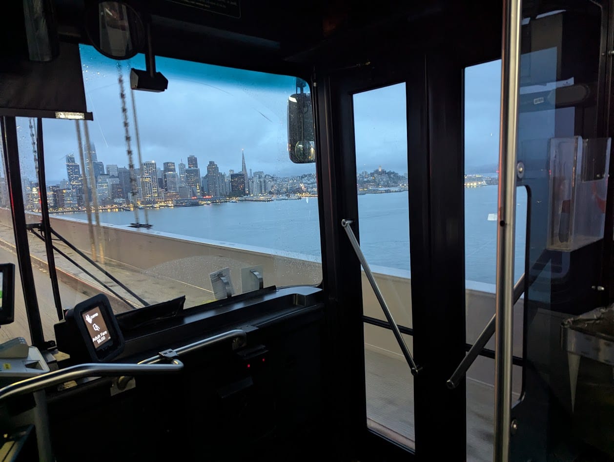 a rainy SF viewed through a bus windshield, on the bay bridge