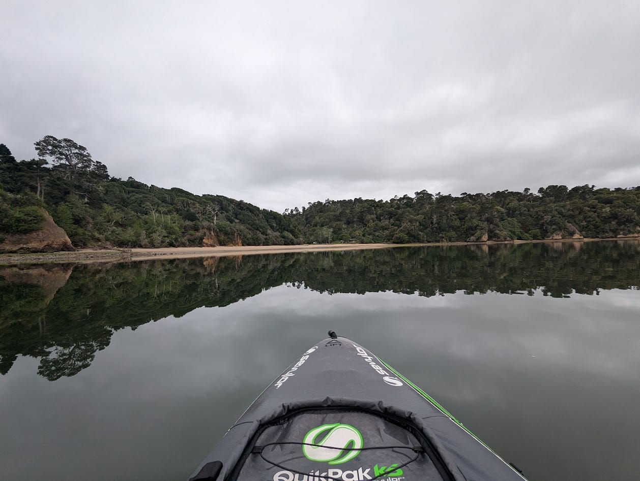 glassy water, clouds, trees, and a kayak