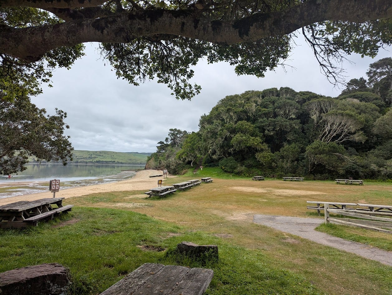 a park with picnic tables and a beach