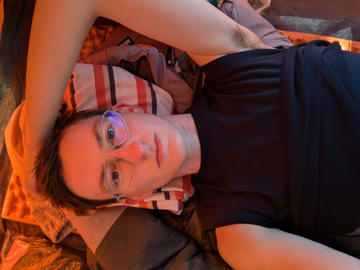 me laying in my tent using the rolled up bag liner as a pillow