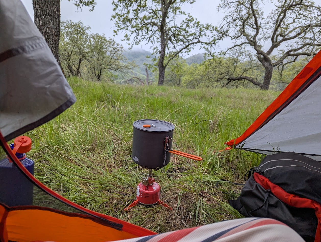 view out of my tent into a cold morning, with a sliver of the striped bag liner material showing