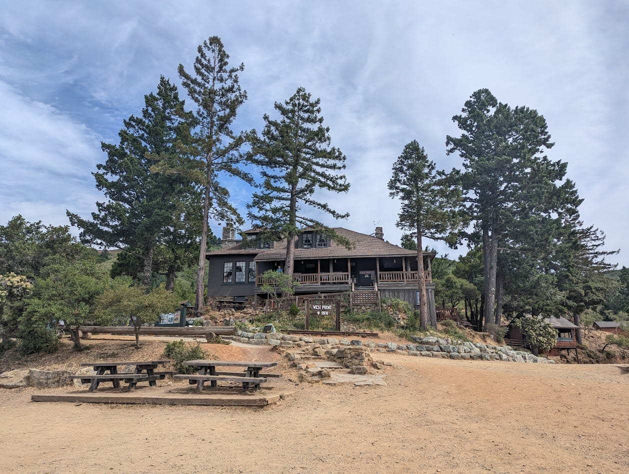 west point inn: a brown wooden lodge type building among trees