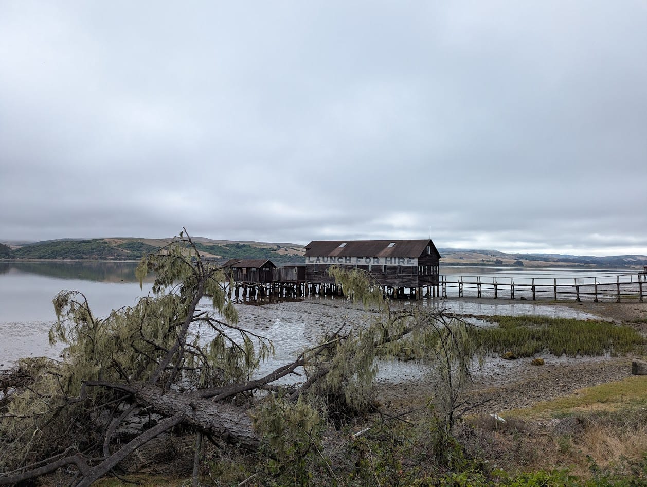 wooden dock building on stilts that says LAUNCH FOR HIRE